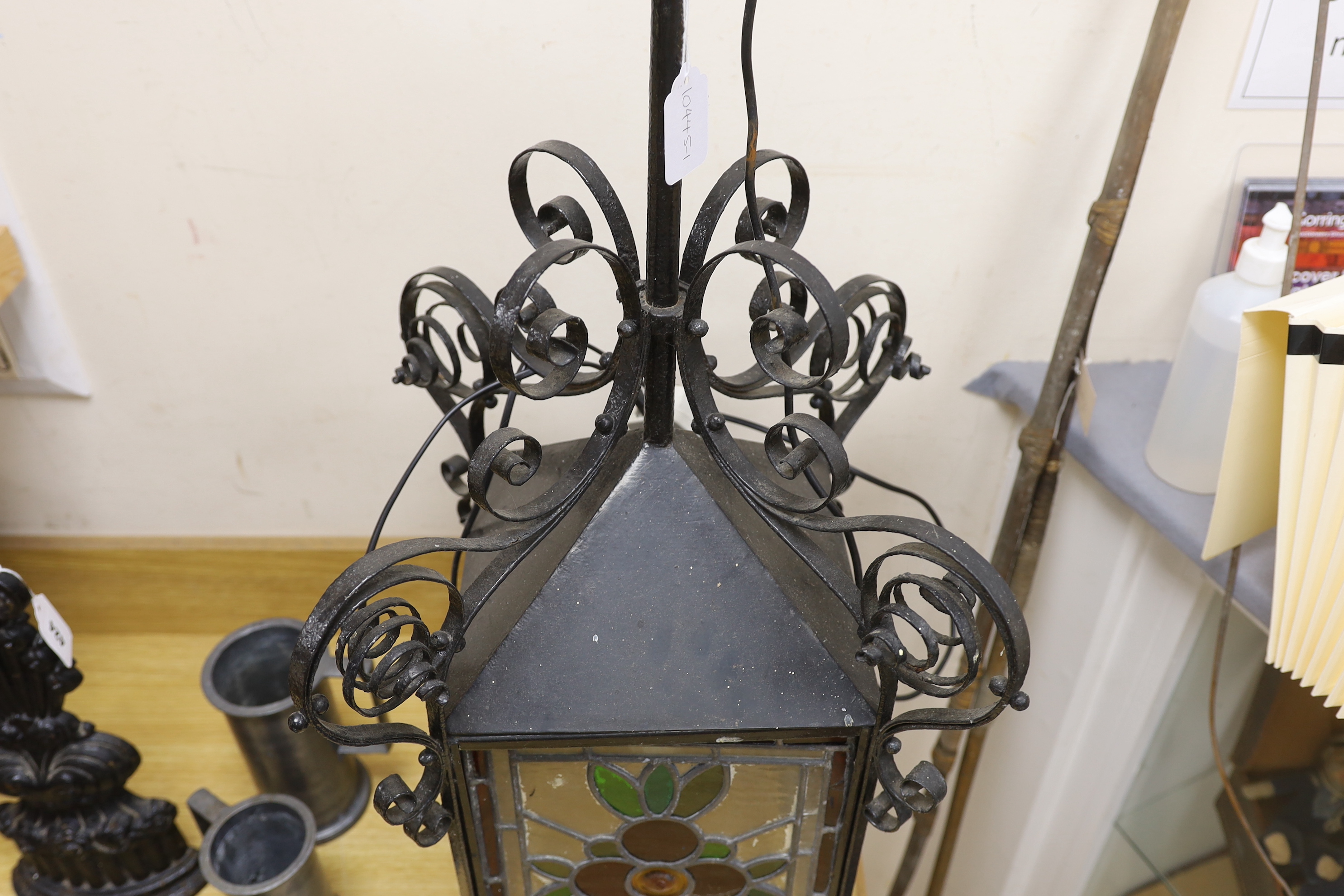 A late 19th/early 20th century Arts and Crafts style wrought iron and stained glass panelled hanging lantern, 80cms high